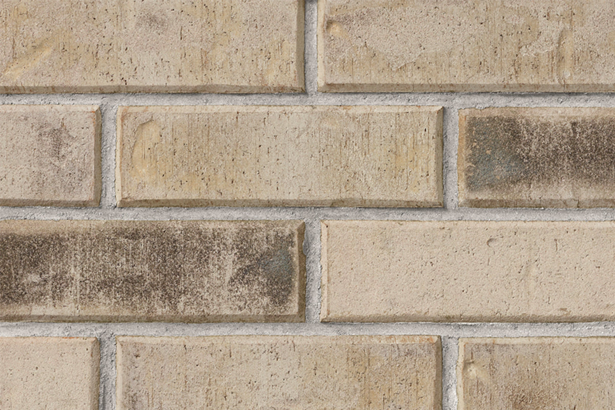 Briques en terre cuite de couleur beige avec des nuances brunes, disposées en motif de maçonnerie.