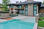 Façade en pierre texturée Pierre Lafitt® avec piscine et patio.