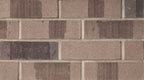Briques en terre cuite de couleur beige et brun, disposées en motif rectangulaire sur un mur.