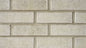Mur de briques beige avec des joints clairs, texture rugueuse et apparence uniforme.