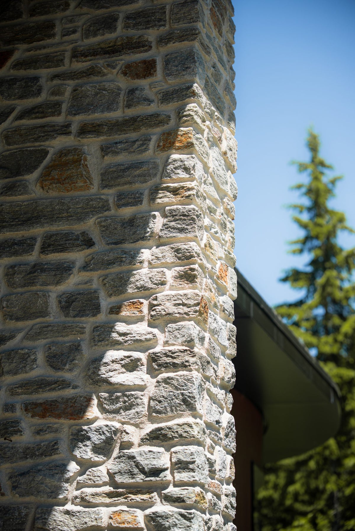 Pierre naturelle grise avec des nuances de brun, utilisée pour le revêtement extérieur et intérieur.
