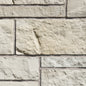 Mur en pierre de couleur beige clair, avec des blocs de différentes tailles et textures, créant un motif naturel.