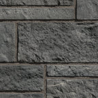 Mur en pierre grise texturée avec des blocs de différentes tailles, offrant un aspect robuste et moderne.