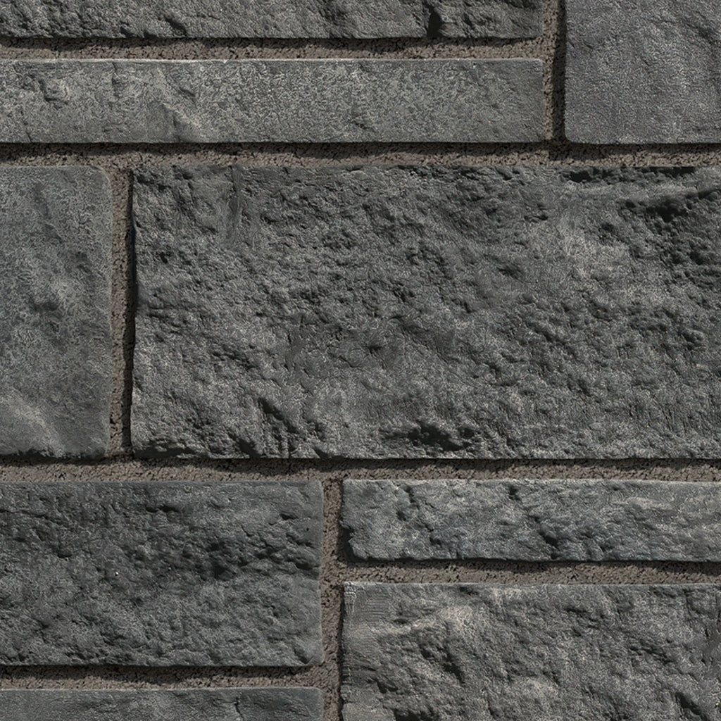 Mur en pierre grise texturée avec des blocs de différentes tailles, offrant un aspect robuste et moderne.