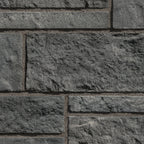 Mur en pierre grise texturée avec des blocs de différentes tailles, offrant un aspect robuste et moderne.