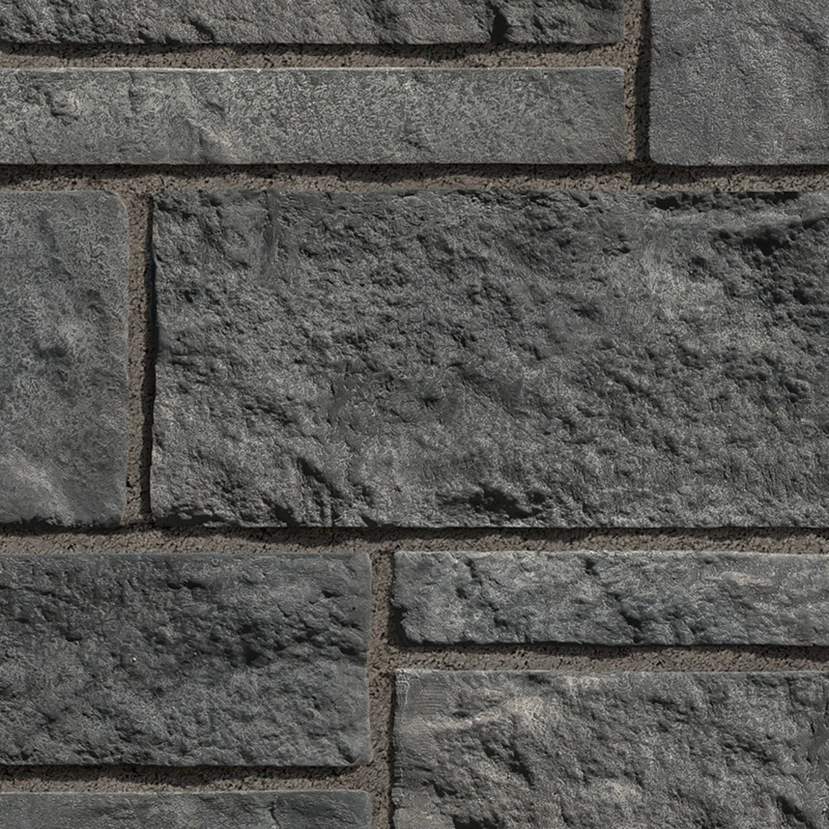 Mur en pierre grise texturée avec des blocs de différentes tailles, offrant un aspect robuste et moderne.