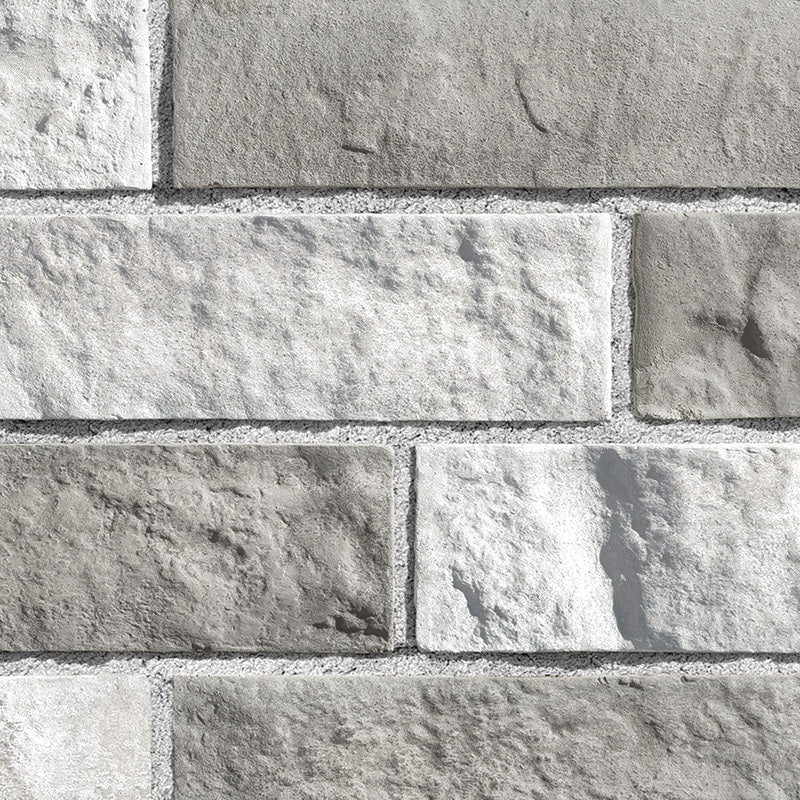 Mur en briques de couleur beige clair avec une texture rugueuse, disposées en motif de maçonnerie.
