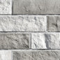 Mur en briques de couleur beige clair avec une texture rugueuse, disposées en motif de maçonnerie.