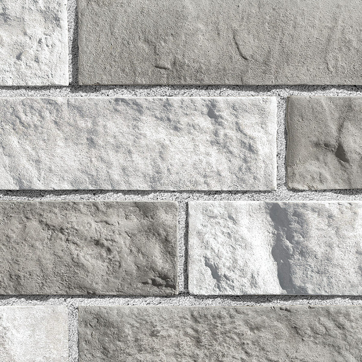 Briques en pierre grise et blanche, avec une texture rugueuse, disposées en motif de maçonnerie.