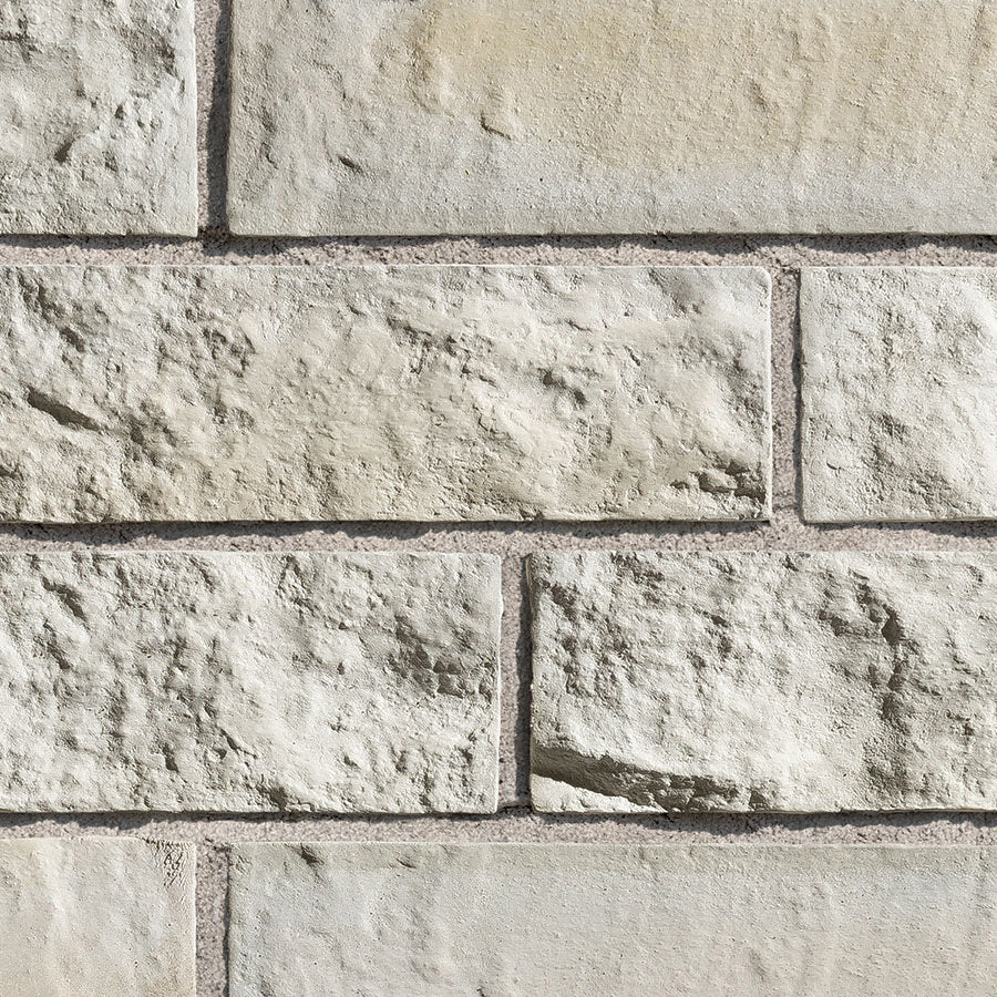 Mur en briques de couleur beige clair avec une texture rugueuse et des joints visibles entre les blocs.