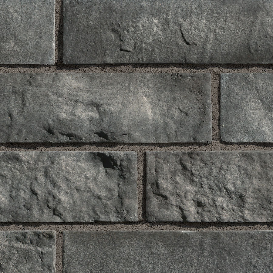 Briques en pierre grise avec texture rugueuse, disposées en motif de maçonnerie.