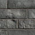 Briques en pierre grise avec texture rugueuse, disposées en motif de maçonnerie.