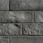 Briques en pierre grise avec texture rugueuse, disposées en motif de maçonnerie.