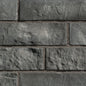 Briques en pierre grise avec texture rugueuse, disposées en motif de maçonnerie.