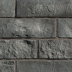Briques en pierre grise avec texture rugueuse, disposées en motif de maçonnerie.