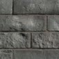 Briques en pierre grise avec texture rugueuse, disposées en motif de maçonnerie.