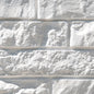 Mur en briques grises texturées avec des joints visibles, créant un effet de maçonnerie.
