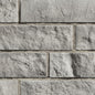 Mur en briques grises texturées, disposées en rangées.