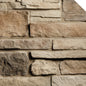 Pierre décorative en différentes teintes de brun et beige, avec des textures variées, disposée en motif de maçonnerie.