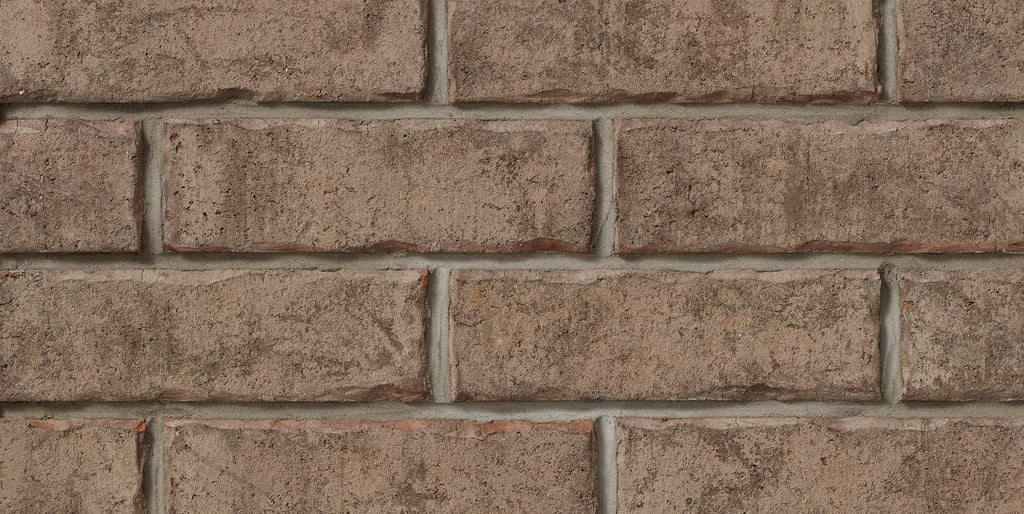 Mur de briques en terre cuite, avec des joints de mortier visibles, affichant une texture rugueuse et des nuances de brun.