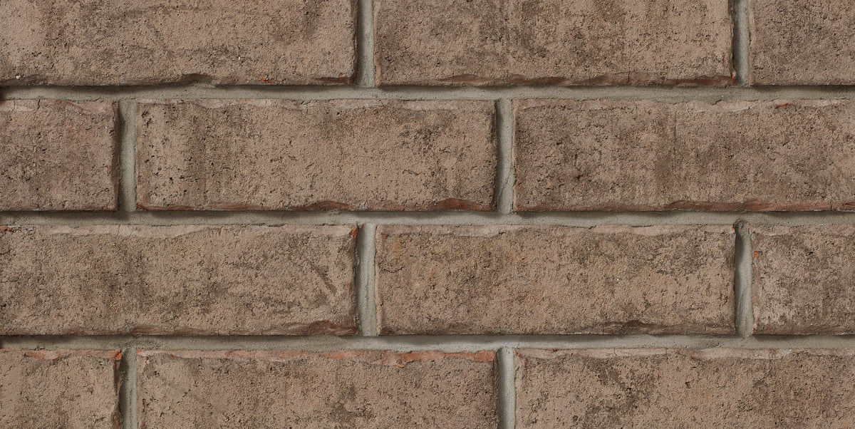 Mur de briques en terre cuite, avec des joints de mortier visibles, affichant une texture rugueuse et des nuances de brun.