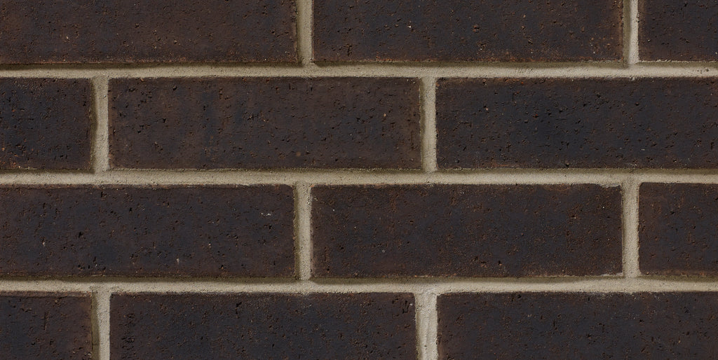 Briques en terre cuite de couleur brun foncé, disposées en motif de maçonnerie sur un mur.