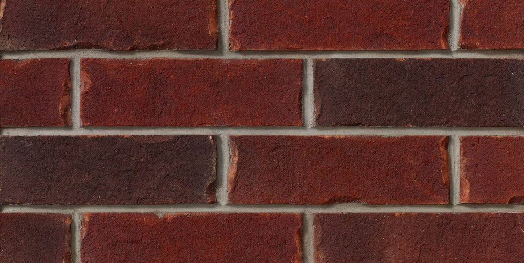 Briques en terre cuite de couleur rouge, disposées en motif régulier avec des joints de mortier gris.