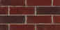 Briques en terre cuite de couleur rouge, disposées en motif de maçonnerie avec des joints de mortier gris.