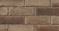 Briques en terre cuite de couleur brun clair et foncé, disposées en motif rectangulaire sur un mur.