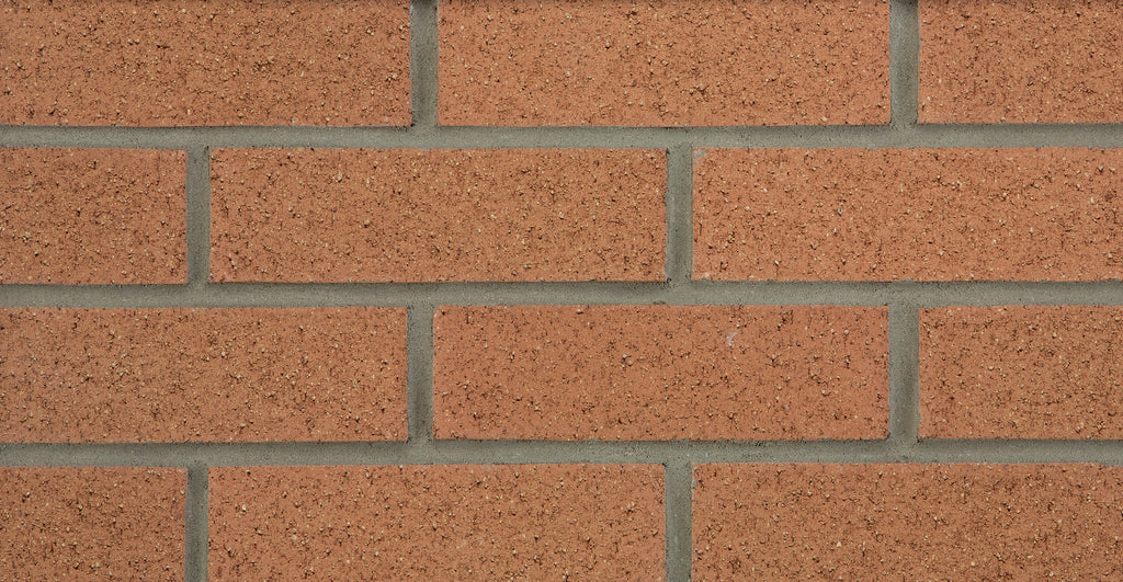 Mur en briques rouges avec joints gris, texture uniforme et disposition en rangées.