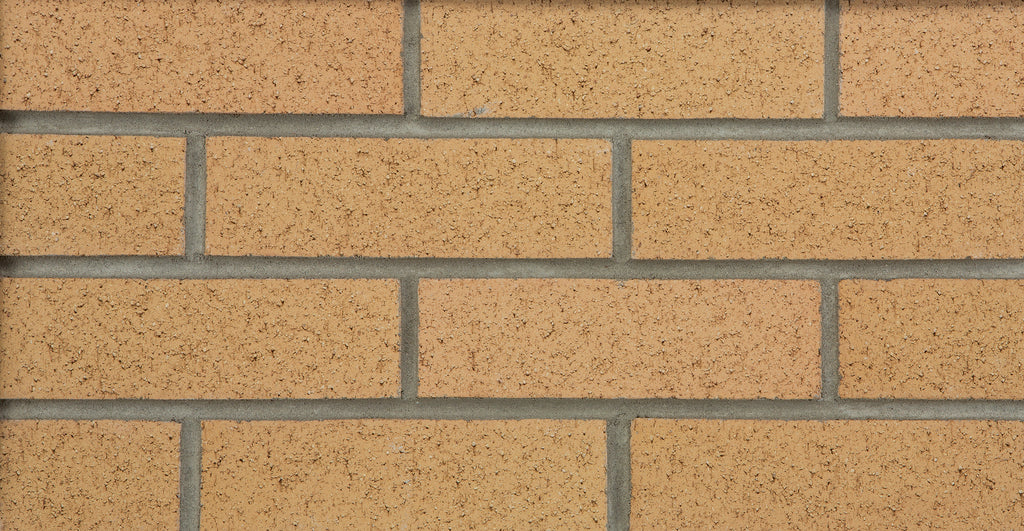 Briques en terre cuite de couleur beige, disposées en rangées avec des joints de mortier gris.