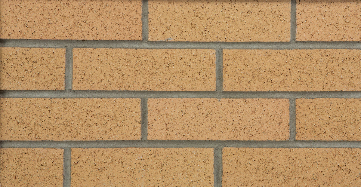 Briques en terre cuite de couleur beige, disposées en rangées avec des joints de mortier gris.