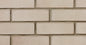 Mur en briques d'argile de couleur beige, avec des joints de mortier visibles entre les briques, texture lisse.
