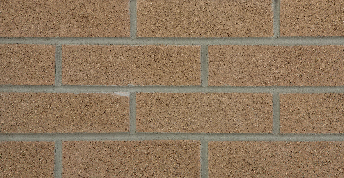 Mur en briques d'argile de couleur brun clair avec des joints gris, texture rugueuse et uniforme.