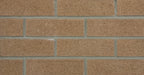 Briques d'argile de couleur beige, disposées en rangées avec des joints gris, texture rugueuse.