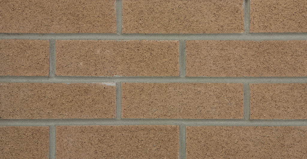 Mur en briques de couleur brun clair avec des joints gris, texture rugueuse et uniforme.