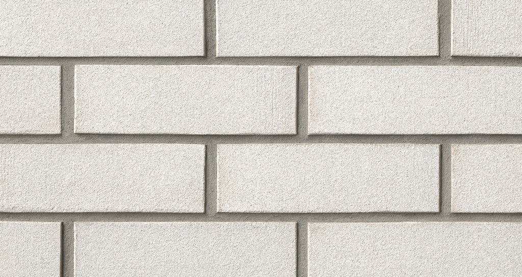 Mur en briques d'argile texturées, disposées en rangées régulières, avec des joints légèrement visibles entre les briques.