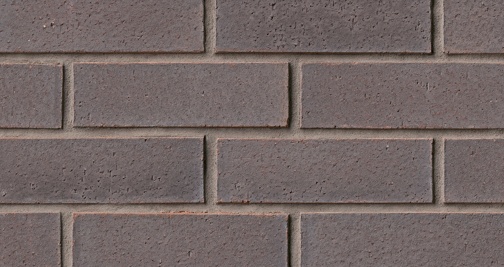 Mur de briques en couleur brun foncé, avec des joints de mortier visibles entre les briques. Texture rugueuse et uniforme.