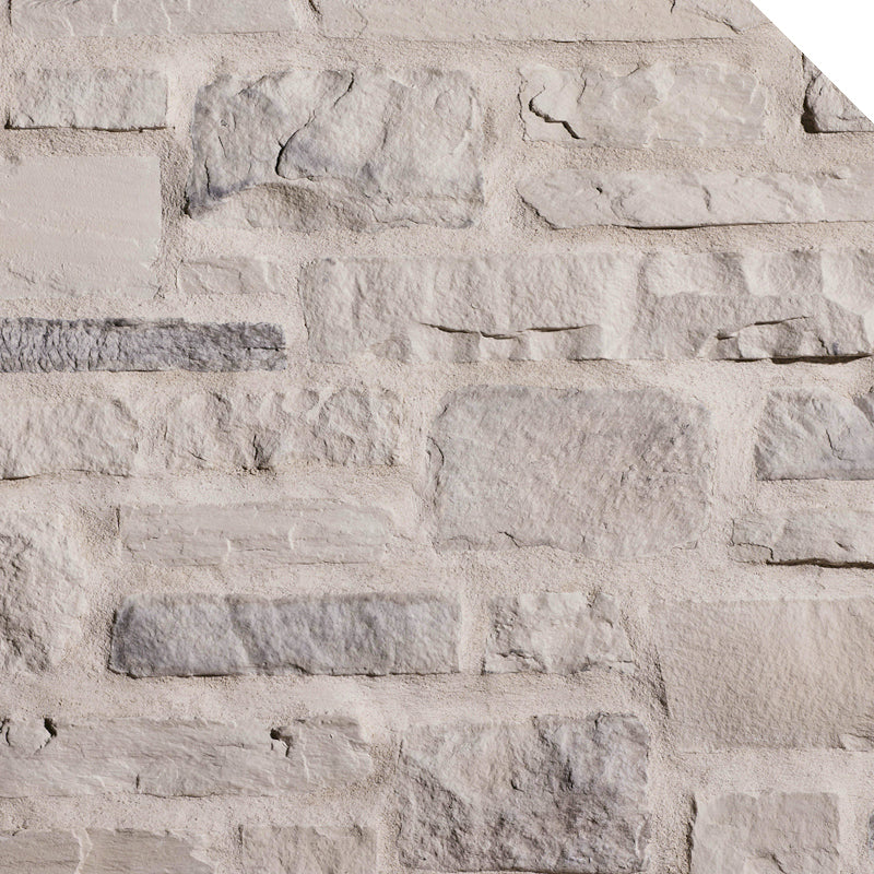 Mur en pierre naturelle de couleur claire, avec des textures variées et des formes irrégulières, créant un aspect rustique.