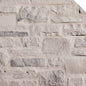 Mur en pierre naturelle de couleur claire, avec des textures variées et des formes irrégulières, créant un aspect rustique.