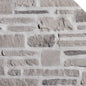 Mur en pierre grise avec des textures variées, incluant des blocs de différentes tailles et formes.