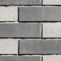 Briques en béton de couleur grise et blanche, disposées en motif alterné sur un mur.