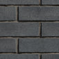 Mur de briques en béton gris foncé, avec une texture rugueuse et des joints visibles entre les briques.