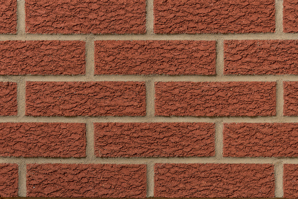 Mur de briques rouges texturées avec des joints en ciment beige, disposées en motif de maçonnerie.
