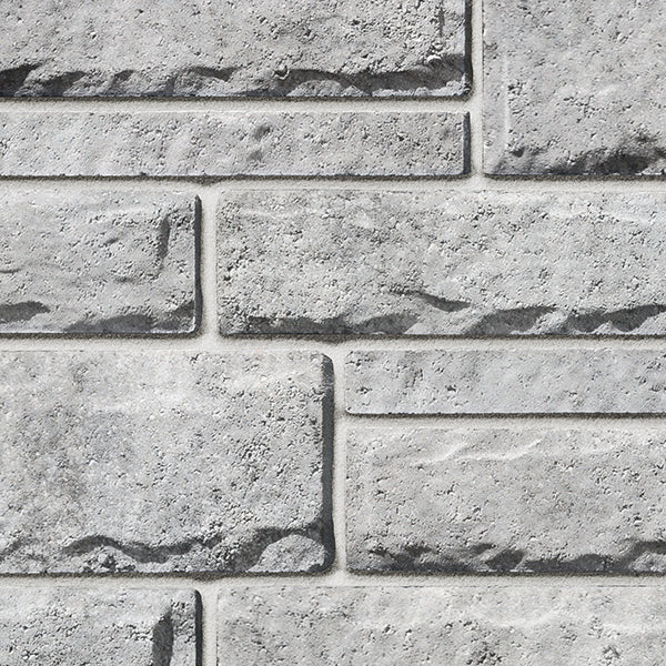 Mur en briques grises texturé, avec des joints visibles et une finition rugueuse, idéal pour des projets de construction ou de décoration.