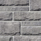 Pierre de béton grise avec texture légèrement ciselée, idéale pour revêtement de façade.