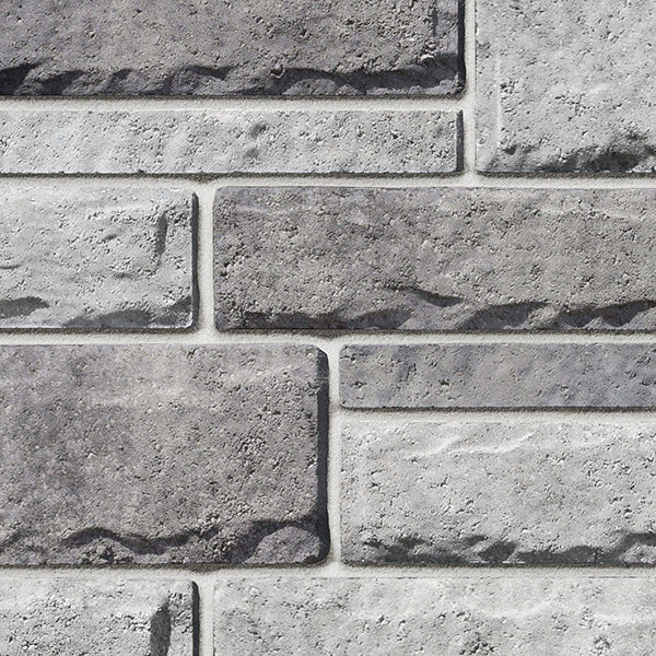 Pierre de béton grise avec texture légèrement ciselée, adaptée pour revêtement de façade.