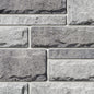 Pierre de béton grise avec texture légèrement ciselée, adaptée pour revêtement de façade.