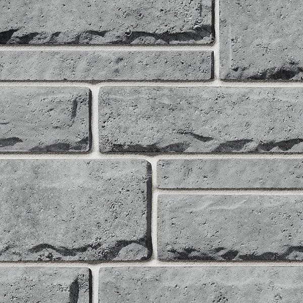 Pierre de béton grise avec texture légèrement ciselée, parfaite pour revêtement de façade.