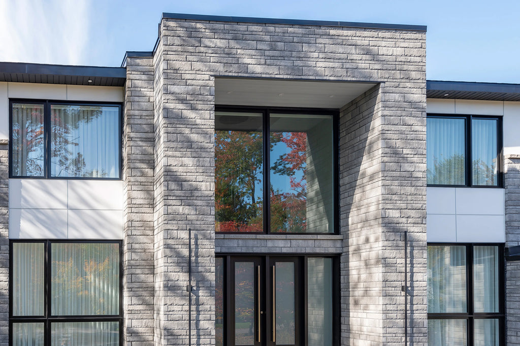 Pierre de béton grise avec texture légèrement ciselée, idéale pour revêtement de façade.